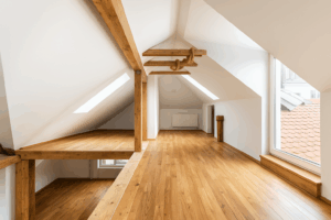 mezzanine-bois-corse photo d’un espace de combles aménagé avec une mezzanine en bois, un sol en parquet massif, des poutres apparentes et de grandes ouvertures pour une luminosité naturelle optimale. Un exemple d’aménagement intérieur haut de gamme réalisé par Corse Solutions Bois en Corse.